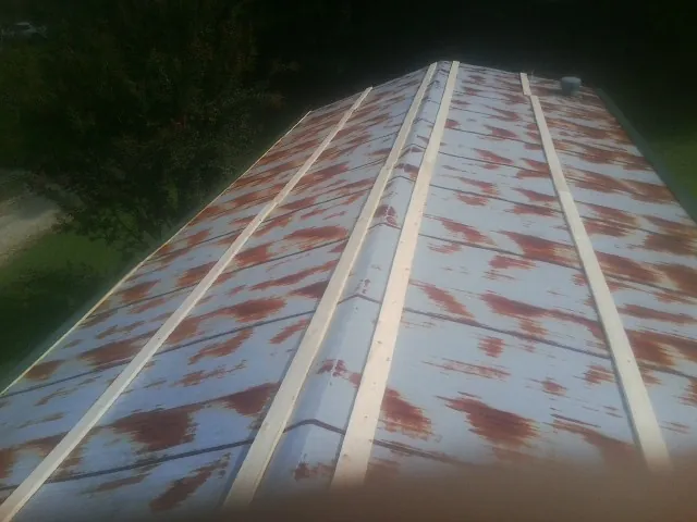 Rusted metal roof panels with new wood purlins before replacement — Storm Damage Roof Repair in Locust Hill by Roofing Brothers